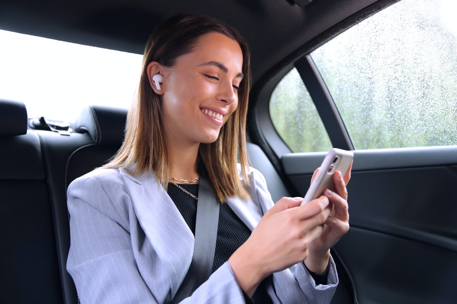 businesswoman-with-wireless-earbuds-commuting-to-work-in-taxi-talking-on-mobile-phone.jpg