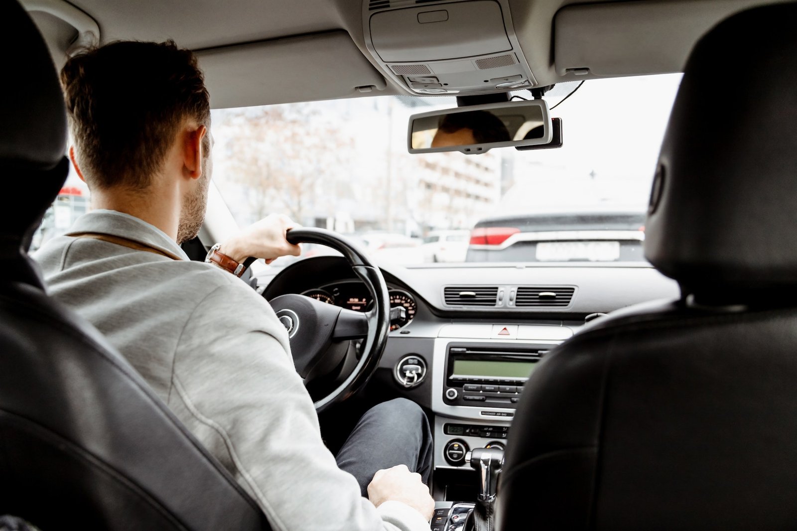 man-in-suit-driving-a-car-personal-driver-business-taxi-back-view-from-saloon.jpg